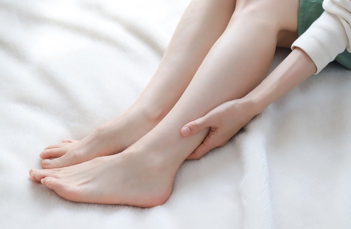 むくみと疲れがとれず足をさする妊娠中のママ